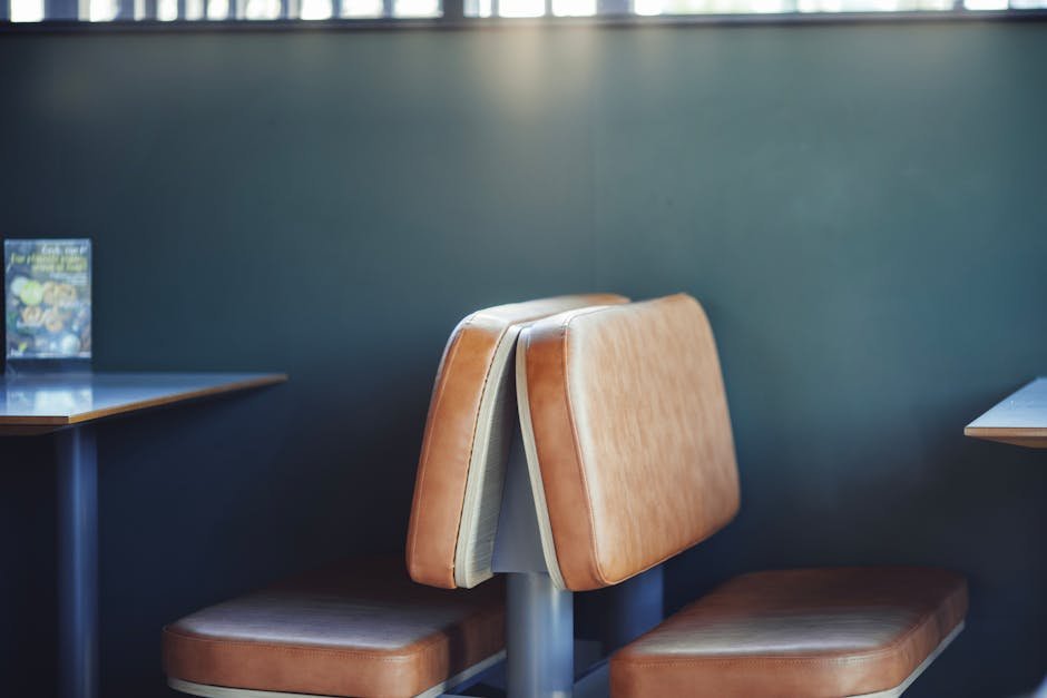 Empty diner booth with a half-drunk coffee mug under fluorescent ceiling lights, the working-class New York register this anora review keeps returning to