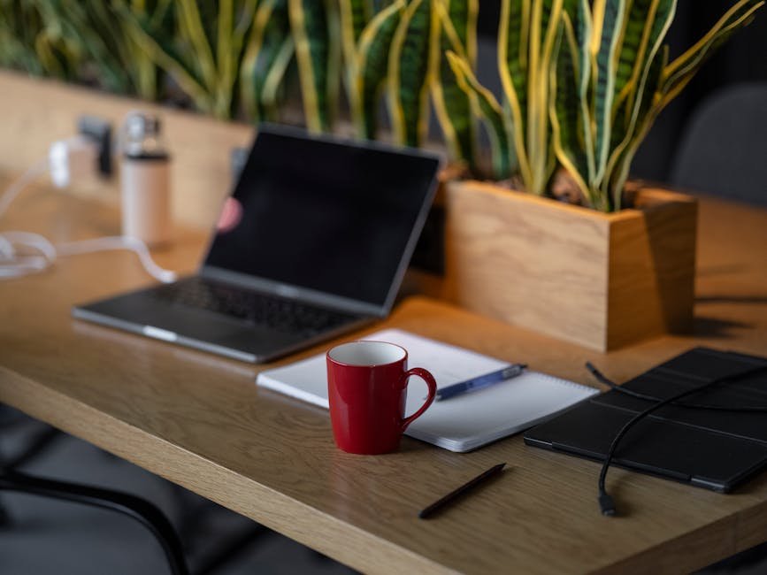 Notebook and red pen on a wooden table beside a single coffee cup, the post-screening writing setup behind a long the substance review of this kind