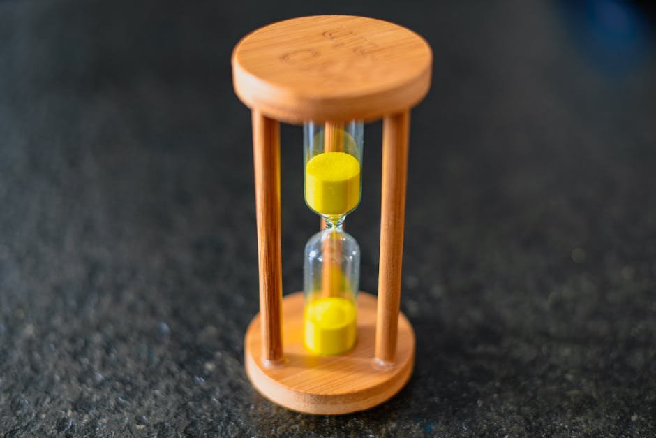 Hourglass sitting on a wooden desk with sand flowing slowly, the literal pacing metaphor this guide to the best slow burn movies returns to