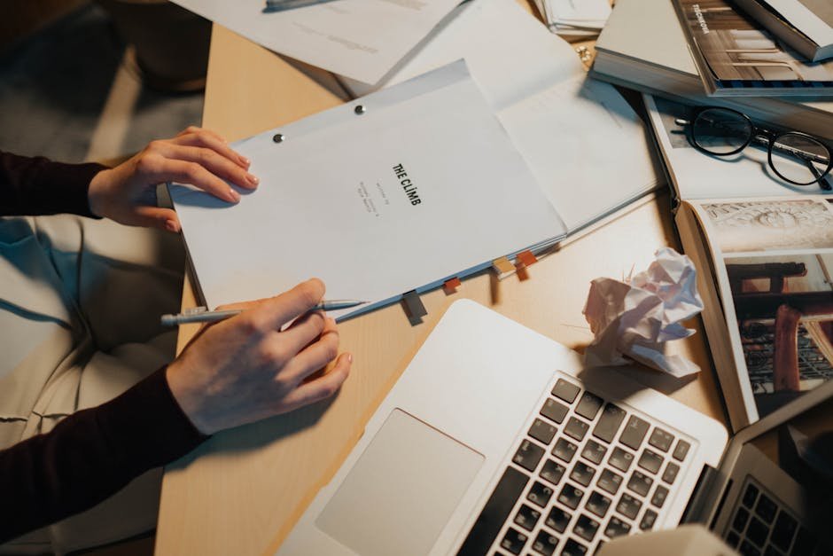 Open laptop and screenplay pages on a desk under warm lamplight, the writing-room context this hit man review keeps returning to for craft observations