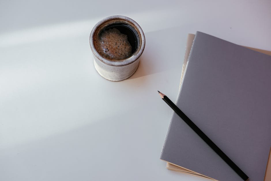 Notebook and coffee cup on a wooden table beside a movie ticket stub, the post-viewing reflection a Conclave review of this length is built on