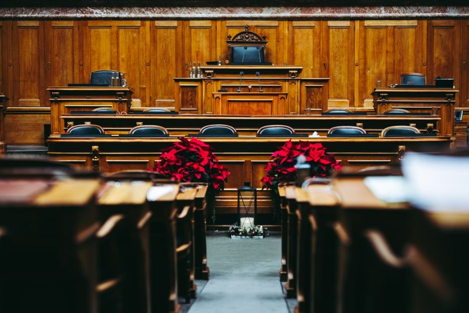 Rows of empty benches in a hushed courtroom interior, a conceptual image for the best courtroom drama movies